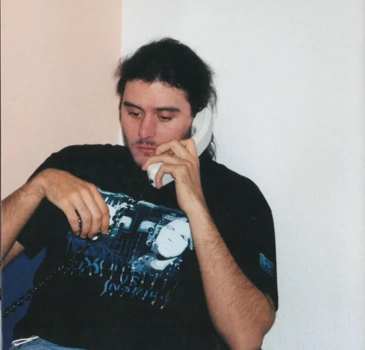 On the telephone, wearing the C.J. Bolland vs Insider tour shirt